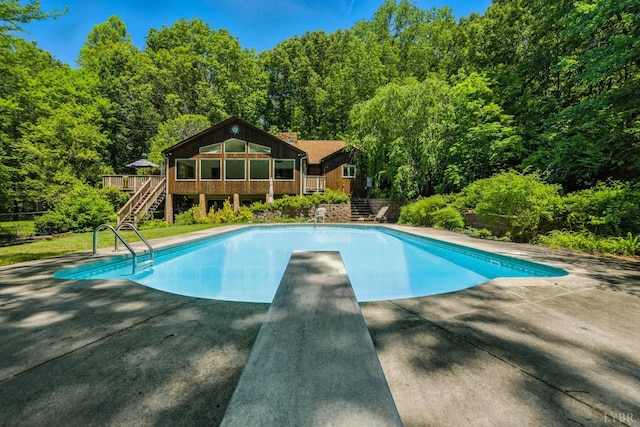 239 Briarcliff Ln, Madison Heights, VA 24572 - swimming pool with stairs, a diving board, a deck, and a wooded view