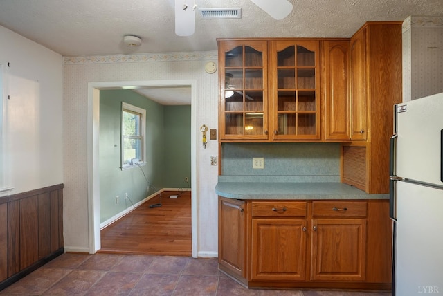 2294 High Peak Rd, Monroe, VA 24574 - kitchen with freestanding refrigerator, a ceiling fan, brown cabinets, glass insert cabinets, and light countertops