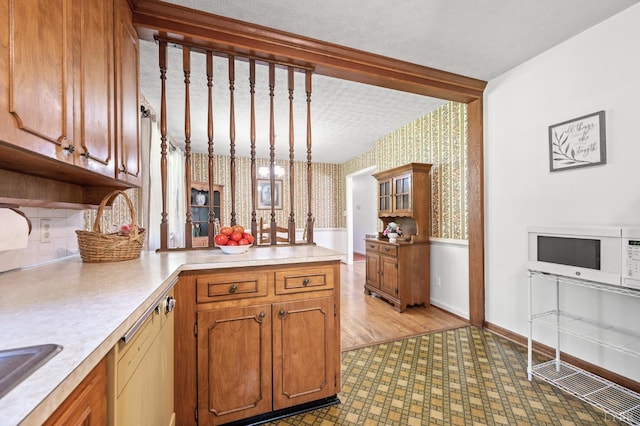 201 Windsor Rd, Lynchburg, VA 24502 - kitchen with wallpapered walls, white microwave, brown cabinets, and light countertops