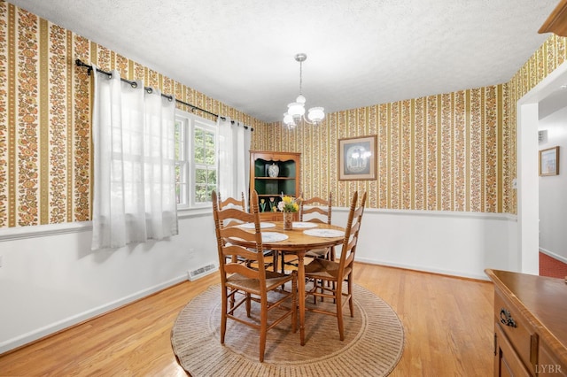 201 Windsor Rd, Lynchburg, VA 24502 - dining room with wallpapered walls, wood finished floors, a chandelier, and a textured ceiling