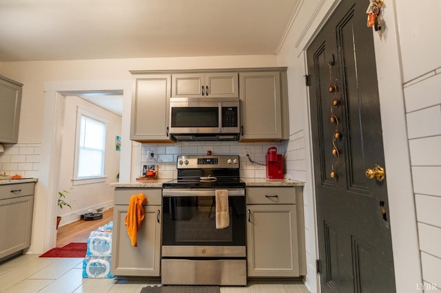 3040 Forest Hills Cir, Lynchburg, VA 24501 - kitchen with appliances with stainless steel finishes, gray cabinets, tasteful backsplash, and light stone countertops