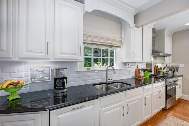 1517 Linden Ave, Lynchburg, VA 24503 - kitchen featuring high end range, wall chimney exhaust hood, white cabinets, tasteful backsplash, and light wood-type flooring