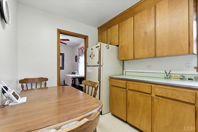 4317 Montgomery Rd, Lynchburg, VA 24503 - kitchen with freestanding refrigerator, light countertops, brown cabinets, and light flooring