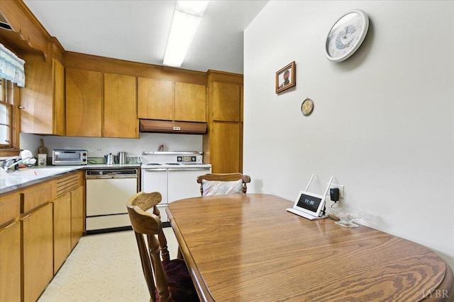 4317 Montgomery Rd, Lynchburg, VA 24503 - kitchen featuring white appliances, under cabinet range hood, brown cabinetry, light countertops, and light floors