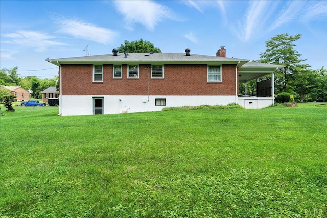 4317 Montgomery Rd, Lynchburg, VA 24503 - rear view of property with a chimney, a yard, brick siding, and a sunroom