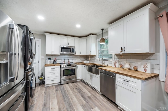 387 Stage Rd, Amherst, VA 24521 - kitchen featuring butcher block countertops, stainless steel appliances, estacked washer and dryer, recessed lighting, and white cabinetry