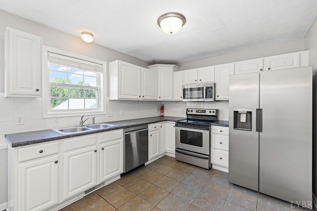 1036 Middle View Dr, Forest, VA 24551 - kitchen with appliances with stainless steel finishes, dark countertops, backsplash, white cabinets, and a textured ceiling