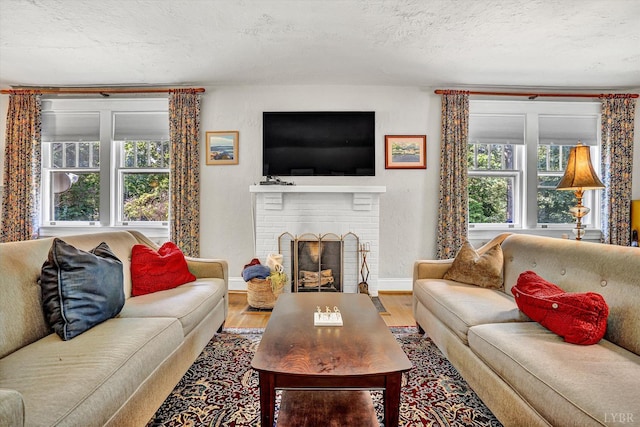 519 Belvedere St, Lynchburg, VA 24503 - living area with wood finished floors, a brick fireplace, and a textured ceiling