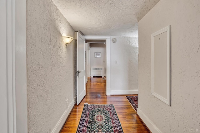519 Belvedere St, Lynchburg, VA 24503 - corridor with a textured wall, wood finished floors, a textured ceiling, and radiator