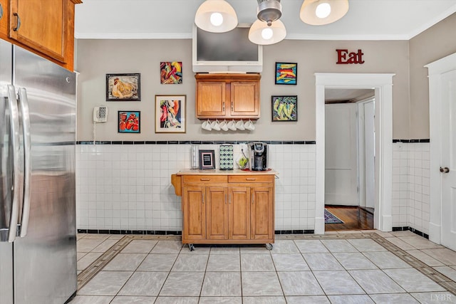 519 Belvedere St, Lynchburg, VA 24503 - kitchen featuring freestanding refrigerator, tile walls, light tile patterned floors, a wainscoted wall, and brown cabinets