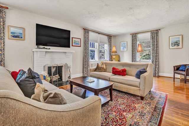 519 Belvedere St, Lynchburg, VA 24503 - living room featuring a textured ceiling, wood finished floors, and a brick fireplace
