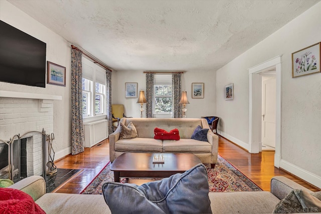 519 Belvedere St, Lynchburg, VA 24503 - living area featuring healthy amount of natural light, wood-type flooring, a textured ceiling, and a brick fireplace