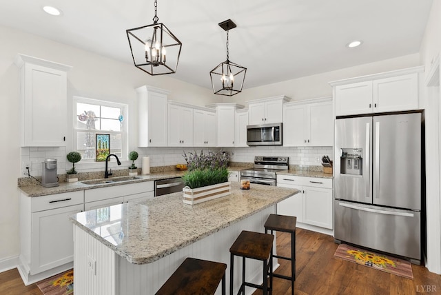1055 Graystone Ln, Forest, VA 24551 - kitchen with appliances with stainless steel finishes, white cabinetry, a kitchen island, tasteful backsplash, and recessed lighting