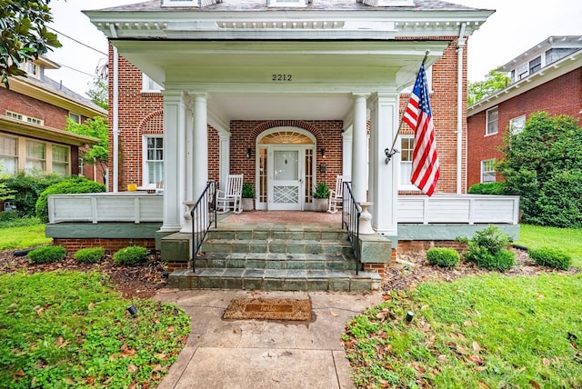 2212 Rivermont Ave, Lynchburg, VA 24503 - view of exterior entry featuring brick siding, mansard roof, and a porch