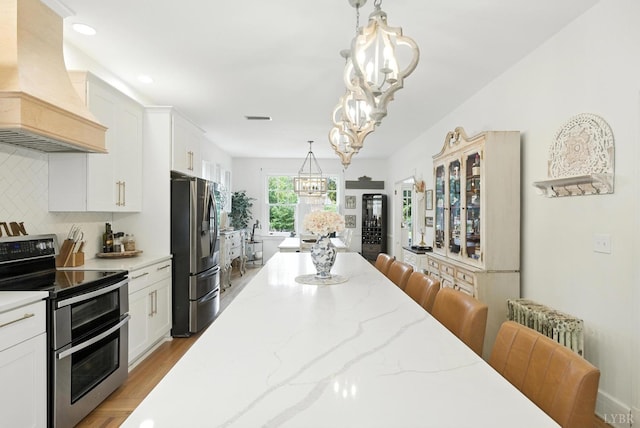 2212 Rivermont Ave, Lynchburg, VA 24503 - kitchen with custom range hood, appliances with stainless steel finishes, a chandelier, white cabinets, and recessed lighting