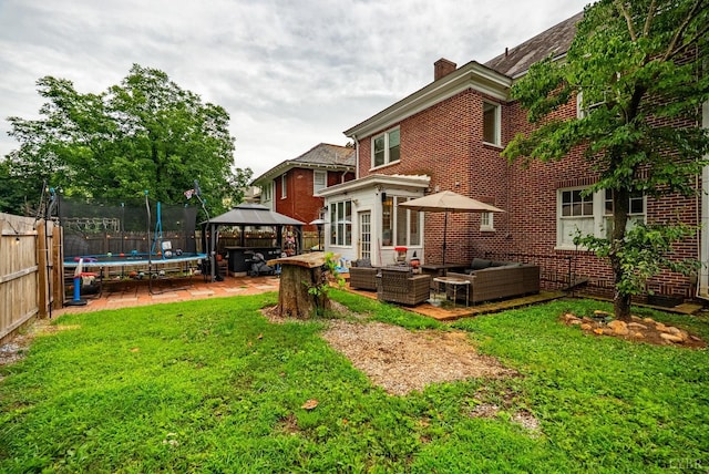 2212 Rivermont Ave, Lynchburg, VA 24503 - rear view of property with a gazebo, outdoor lounge area, a trampoline, brick siding, and a fenced backyard