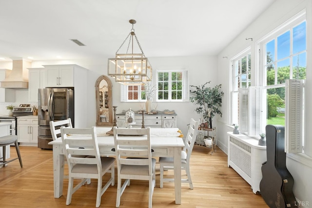 2212 Rivermont Ave, Lynchburg, VA 24503 - dining space featuring radiator, a chandelier, and light wood-type flooring
