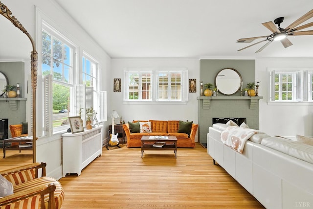 2212 Rivermont Ave, Lynchburg, VA 24503 - living room featuring a fireplace, radiator, light wood finished floors, a ceiling fan, and ornamental molding
