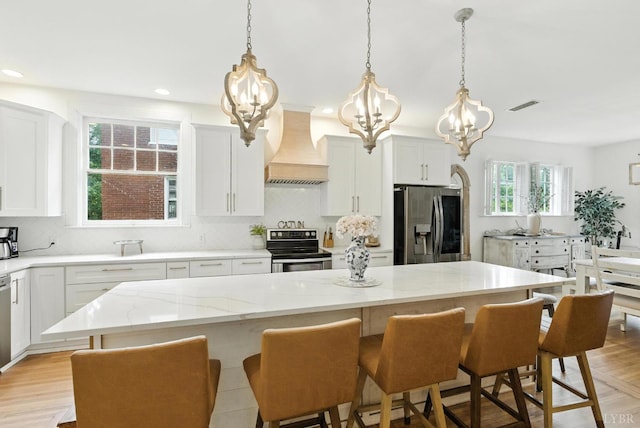 2212 Rivermont Ave, Lynchburg, VA 24503 - kitchen featuring custom exhaust hood, stainless steel appliances, a chandelier, backsplash, and a breakfast bar area
