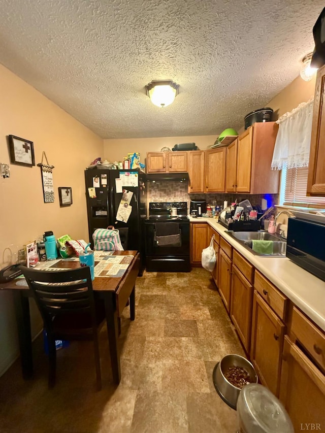 1119 Tyree St, Lynchburg, VA 24504 - kitchen with black appliances, light countertops, under cabinet range hood, brown cabinets, and a textured ceiling
