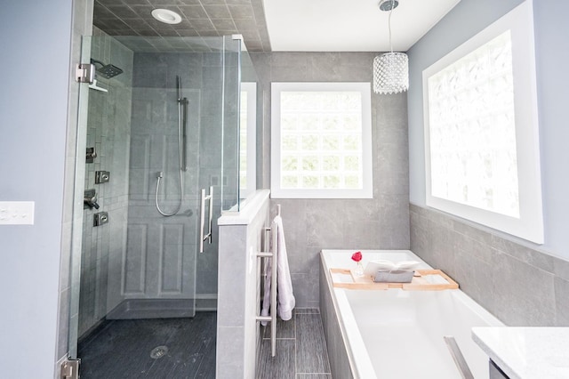 102 Stirling Ct, Forest, VA 24551 - full bathroom with tile walls, a shower stall, a garden tub, and a chandelier