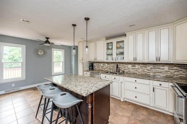 102 Stirling Ct, Forest, VA 24551 - kitchen with stainless steel appliances, a kitchen island, decorative backsplash, light stone countertops, and a ceiling fan