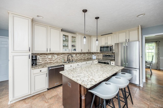102 Stirling Ct, Forest, VA 24551 - kitchen featuring stainless steel appliances, cream cabinets, a center island, light stone counters, and a textured ceiling