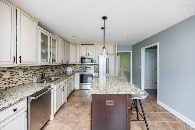 102 Stirling Ct, Forest, VA 24551 - kitchen featuring stainless steel appliances, backsplash, cream cabinetry, a kitchen bar, and light stone counters