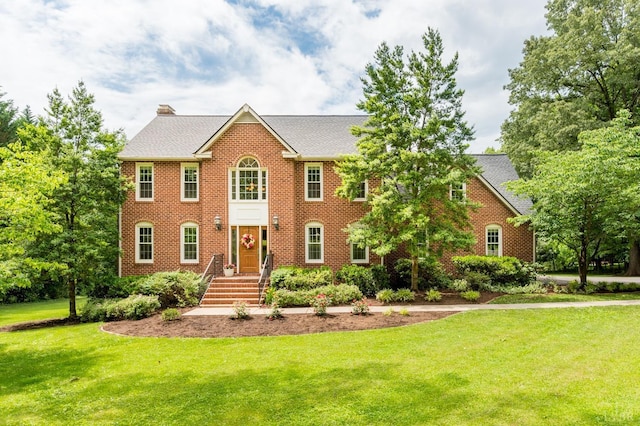 102 Stirling Ct, Forest, VA 24551 - colonial home with a front lawn, a chimney, brick siding, and roof with shingles