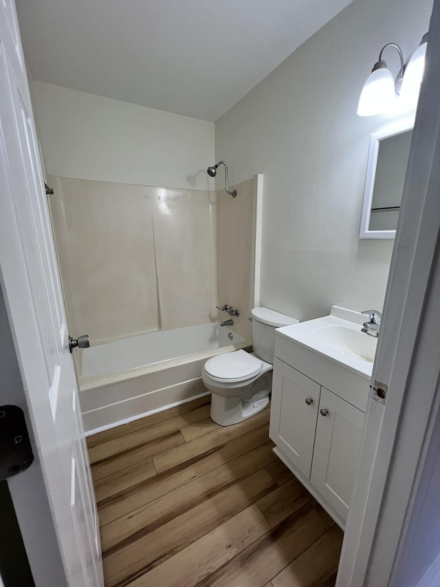 full bathroom featuring vanity, toilet, wood-type flooring, and washtub / shower combination