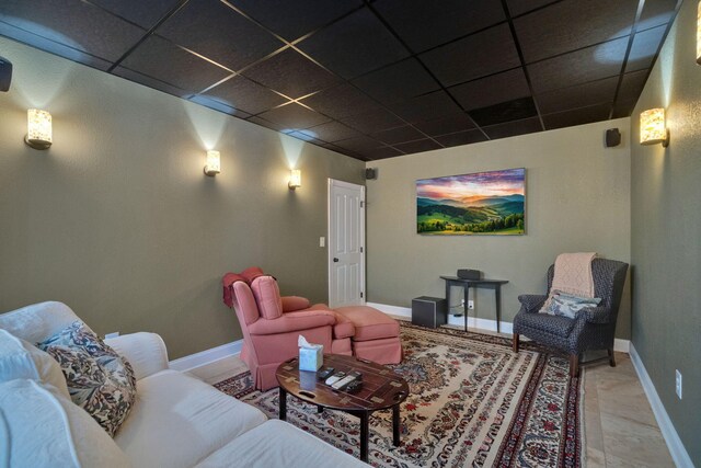 cinema featuring a drop ceiling and baseboards