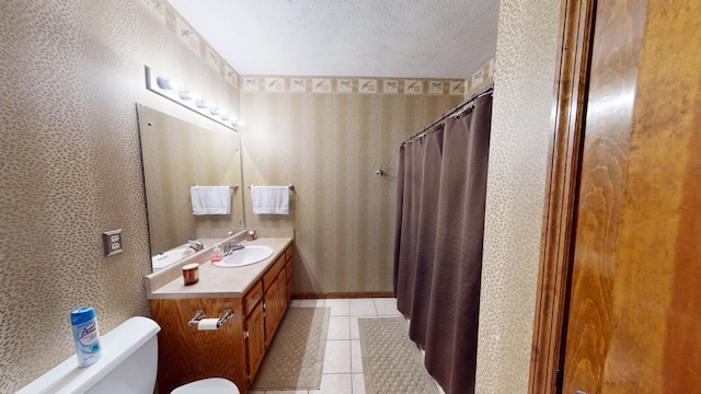 bathroom featuring tile patterned floors, vanity, a textured ceiling, and toilet