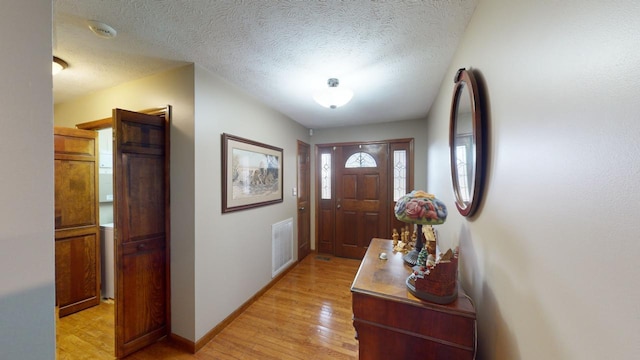 entrance foyer featuring light hardwood / wood-style floors and a textured ceiling