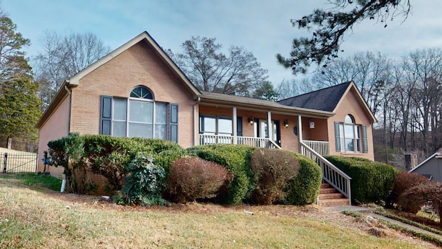 ranch-style home featuring a porch and a front lawn