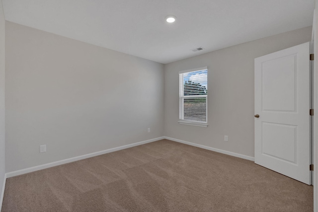 unfurnished room featuring carpet, baseboards, and visible vents