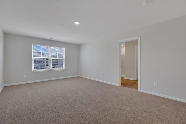 carpeted empty room with baseboards