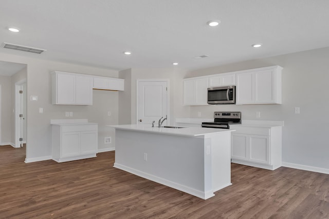 kitchen with wood finished floors, appliances with stainless steel finishes, a sink, and visible vents