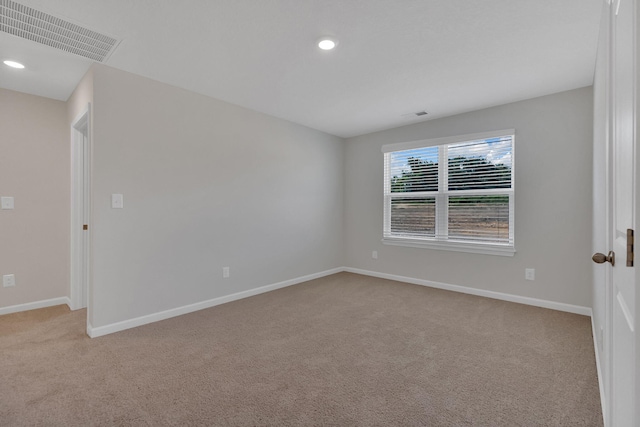 spare room featuring recessed lighting, carpet, visible vents, and baseboards