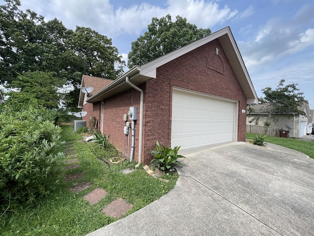 view of home's exterior with brick siding, driveway, and central AC