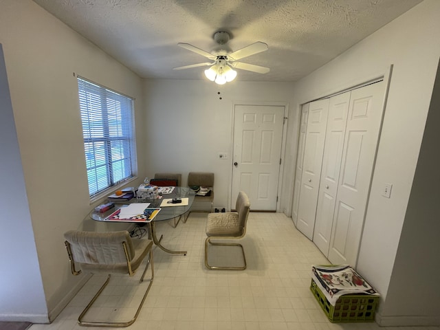 office featuring a ceiling fan, a textured ceiling, and baseboards