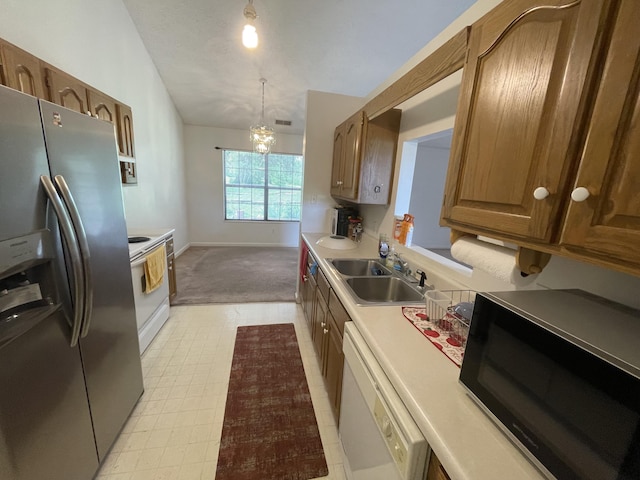 kitchen with white appliances, a sink, light countertops, baseboards, and a chandelier