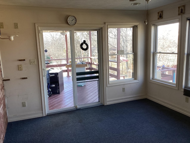 doorway with dark colored carpet and ornamental molding