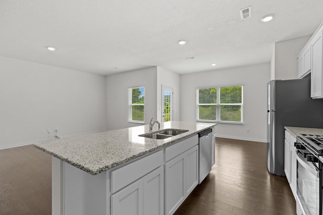 305 Eclipse Ln, Knoxville, TN 37924 - kitchen featuring appliances with stainless steel finishes, dark wood-type flooring, an island with sink, light stone countertops, and recessed lighting