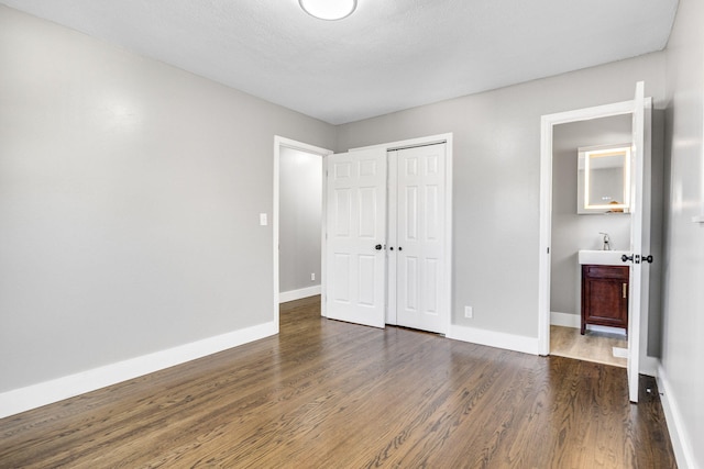 unfurnished bedroom with dark wood-type flooring