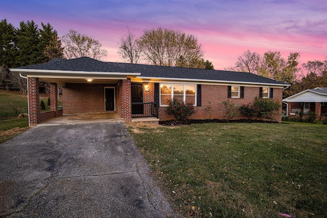 ranch-style house featuring a carport and a yard