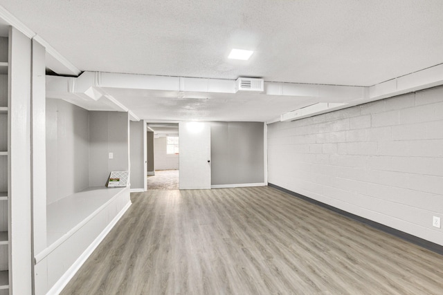 basement with wood-type flooring and a textured ceiling