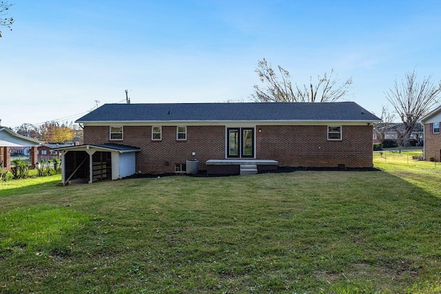 rear view of property featuring cooling unit and a yard