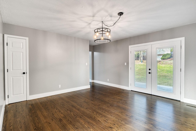 interior space featuring dark hardwood / wood-style flooring, french doors, and an inviting chandelier