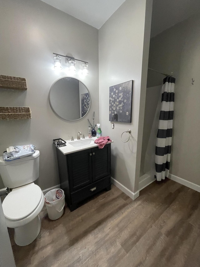 bathroom featuring curtained shower, vanity, wood finished floors, and baseboards