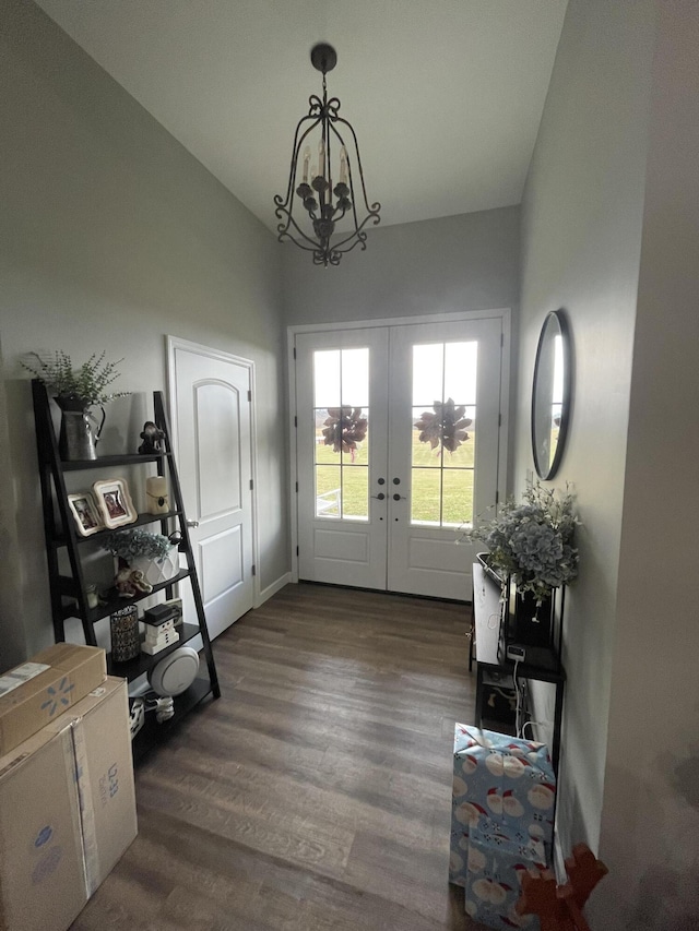 entrance foyer with lofted ceiling, dark hardwood / wood-style floors, french doors, and a chandelier